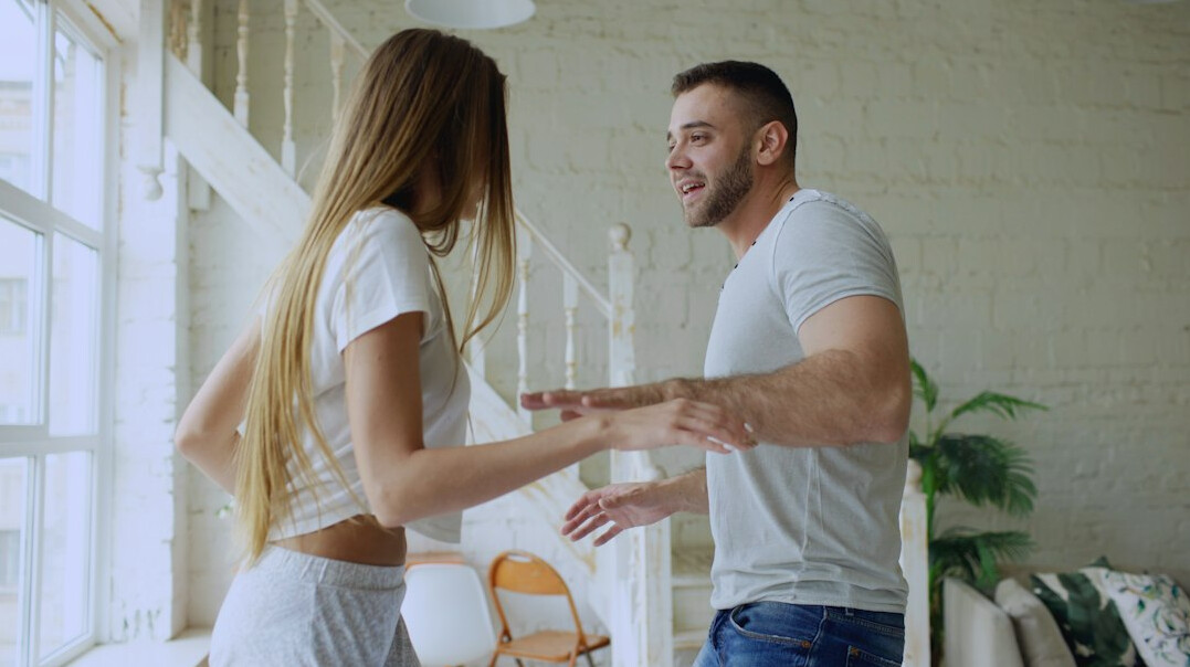 Two people shaking hands warmly indoors