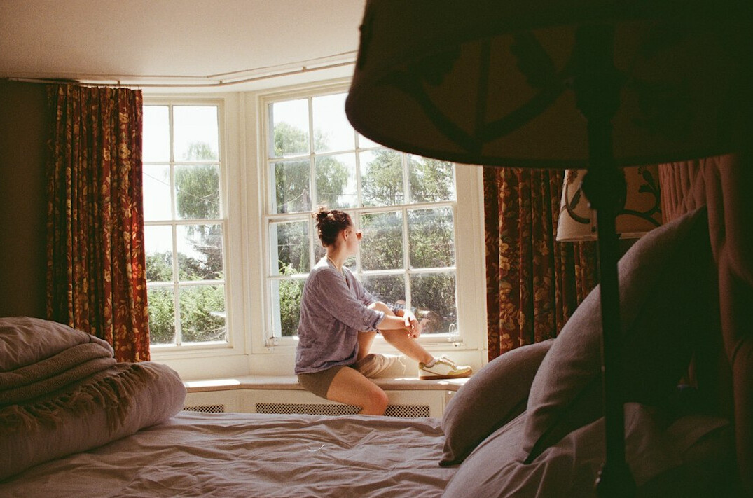 Brazilian woman writing in a journal near a window